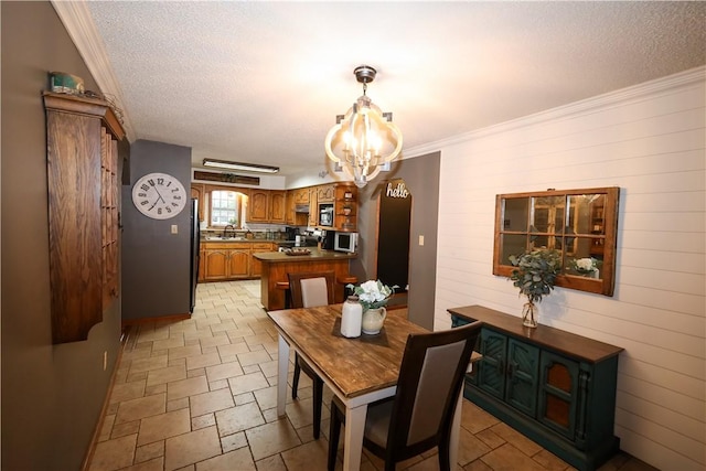 4639 Quail Ct, Harrison, AR 72601 - dining space featuring a chandelier, a textured ceiling, crown molding, light stone finish floors, and wooden walls