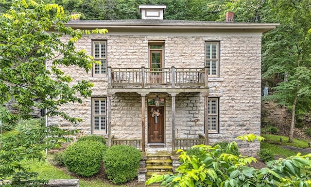32 Armstrong St, Eureka Springs, AR 72632 - view of front of house with a balcony, covered porch, a chimney, and stone siding