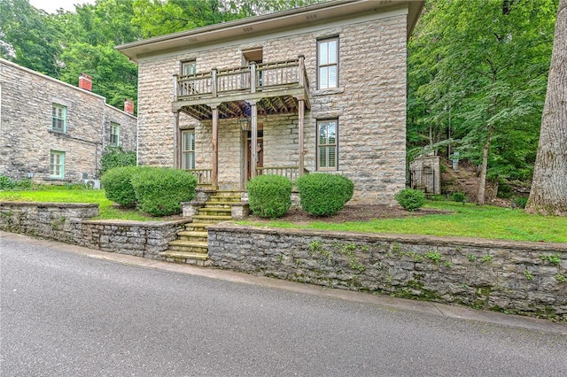32 Armstrong St, Eureka Springs, AR 72632 - view of front of property featuring a balcony, stone siding, and a porch