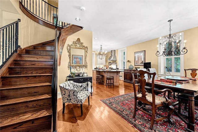 32 Armstrong St, Eureka Springs, AR 72632 - dining space featuring a chandelier, stairs, and light wood-type flooring