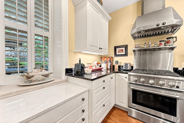 32 Armstrong St, Eureka Springs, AR 72632 - kitchen with high end range, wall chimney range hood, white cabinetry, open shelves, and light wood finished floors
