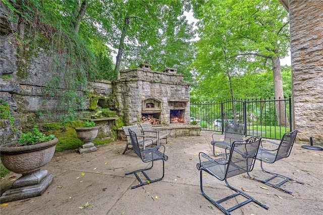 32 Armstrong St, Eureka Springs, AR 72632 - view of patio / terrace featuring an outdoor stone fireplace and view of scattered trees