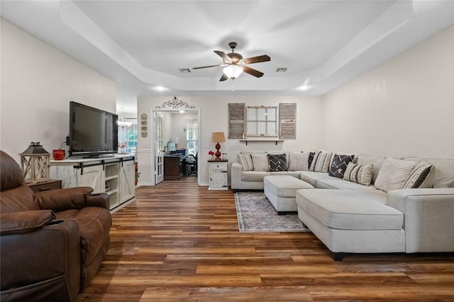 16 Olmsted Ln, Bella Vista, AR 72715 - living area featuring a raised ceiling, wood finished floors, a ceiling fan, and a chandelier
