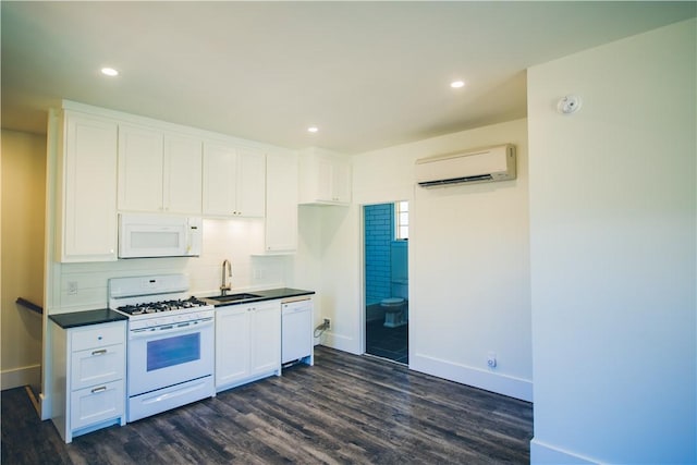218 E S St, Fayetteville, AR 72701 - kitchen with white appliances, a wall unit AC, dark wood finished floors, white cabinets, and dark countertops