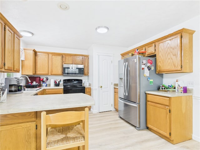 104 Paradise Cove Ln, Berryville, AR 72616 - kitchen featuring stainless steel appliances, light countertops, a peninsula, light wood-style flooring, and a kitchen breakfast bar