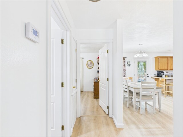 104 Paradise Cove Ln, Berryville, AR 72616 - corridor featuring light wood finished floors and a chandelier