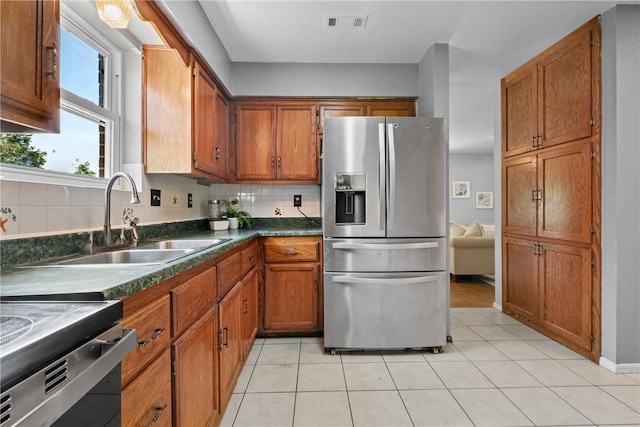 2511 Purdue Cir, Bentonville, AR 72712 - kitchen with appliances with stainless steel finishes, brown cabinets, and decorative backsplash