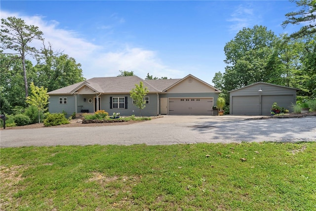 8252 Hickory Tree Ln, Rogers, AR 72756 - ranch-style house featuring a front lawn, a detached garage, and an outbuilding