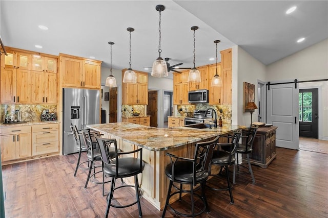 8252 Hickory Tree Ln, Rogers, AR 72756 - kitchen with stainless steel appliances, a barn door, a peninsula, dark wood-style flooring, and light stone countertops