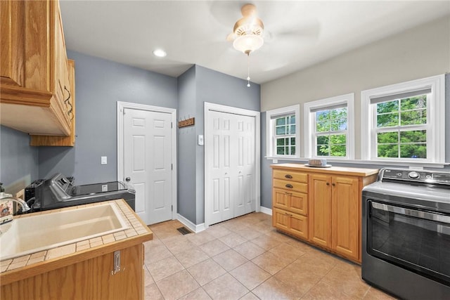 8252 Hickory Tree Ln, Rogers, AR 72756 - kitchen featuring washer / clothes dryer, tile countertops, light tile patterned floors, and ceiling fan