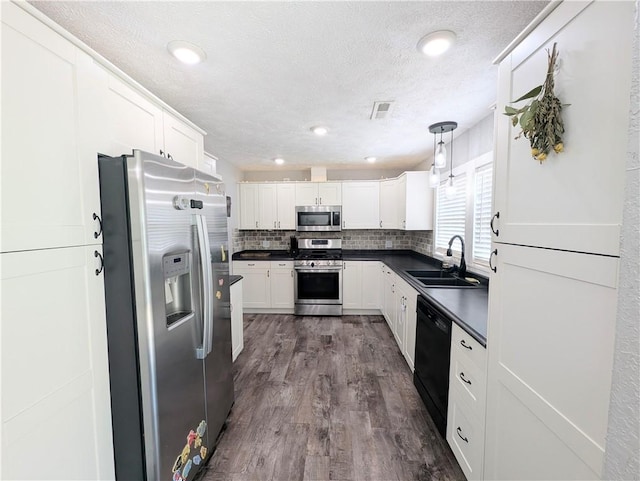 805 S Oak St, Harrison, AR 72601 - kitchen featuring appliances with stainless steel finishes, dark countertops, a textured ceiling, white cabinets, and backsplash