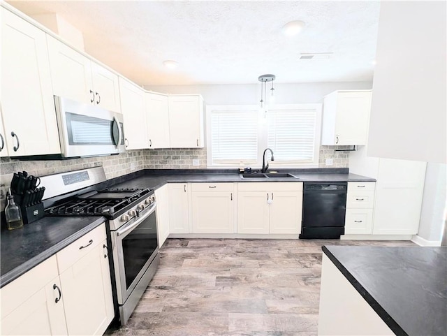 805 S Oak St, Harrison, AR 72601 - kitchen with appliances with stainless steel finishes, dark countertops, decorative backsplash, white cabinetry, and light wood-style floors