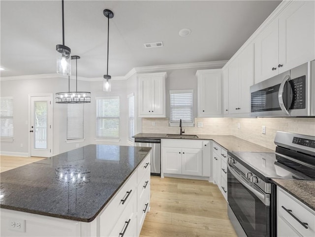 11 Dornoch Cir, Bella Vista, AR 72715 - kitchen featuring appliances with stainless steel finishes, crown molding, light wood-style floors, a center island, and white cabinets