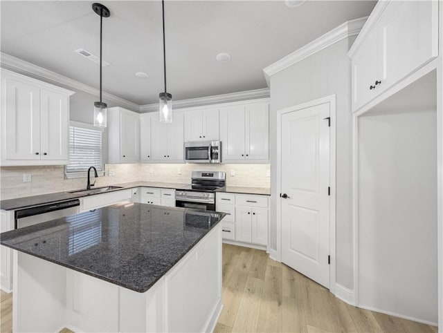 11 Dornoch Cir, Bella Vista, AR 72715 - kitchen with stainless steel appliances, light wood-type flooring, white cabinets, tasteful backsplash, and hanging light fixtures
