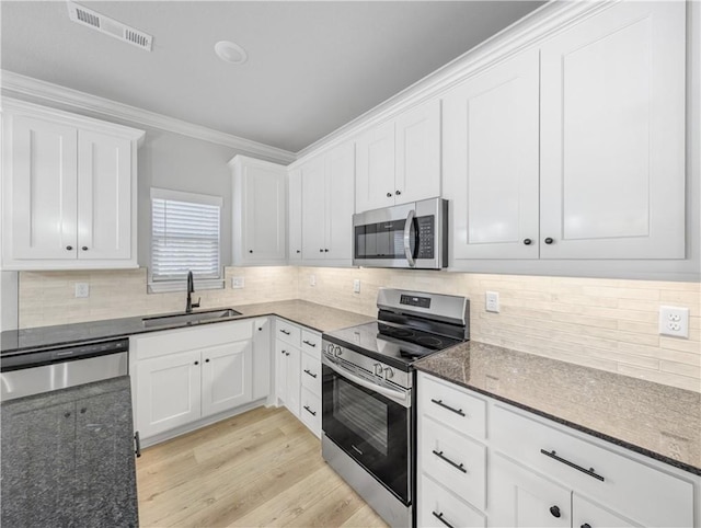 11 Dornoch Cir, Bella Vista, AR 72715 - kitchen featuring stainless steel appliances, dark stone countertops, white cabinets, decorative backsplash, and crown molding