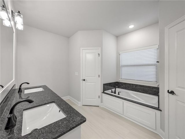 11 Dornoch Cir, Bella Vista, AR 72715 - bathroom featuring double vanity, a garden tub, recessed lighting, and wood finished floors