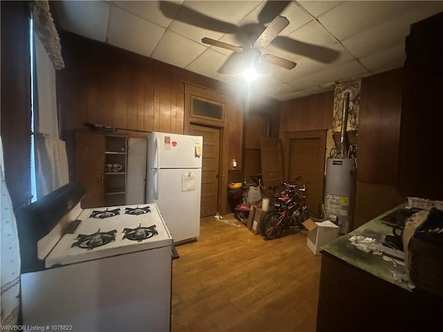 1200 N 8th St, Fort Smith, AR 72901 - kitchen featuring white appliances, a ceiling fan, wooden walls, gas water heater, and wood finished floors