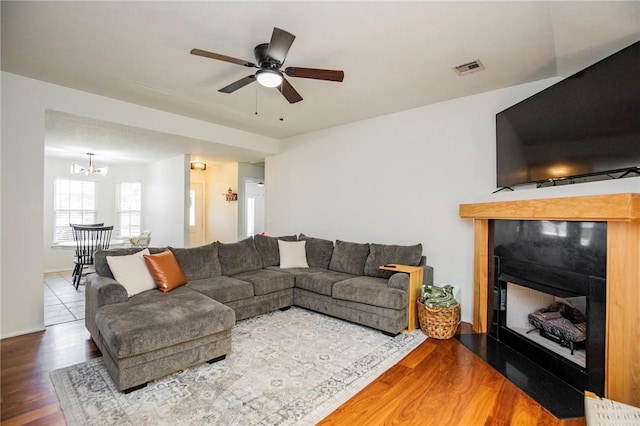 1041 Evergreen St, Centerton, AR 72719 - living area with a fireplace, wood finished floors, a chandelier, and a ceiling fan