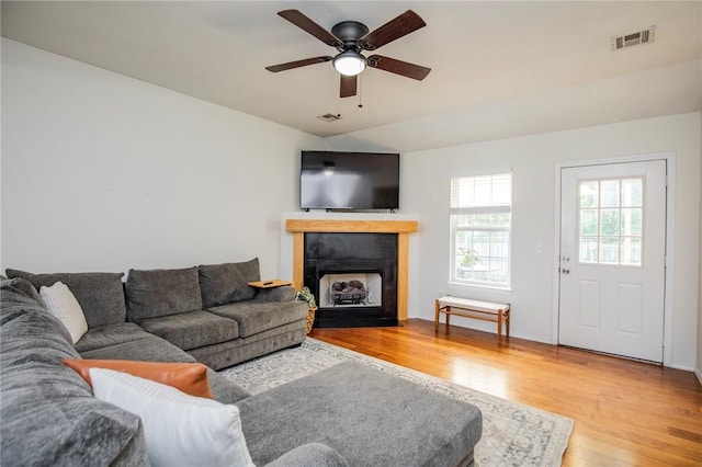 1041 Evergreen St, Centerton, AR 72719 - living room featuring wood finished floors, a ceiling fan, and a fireplace with flush hearth