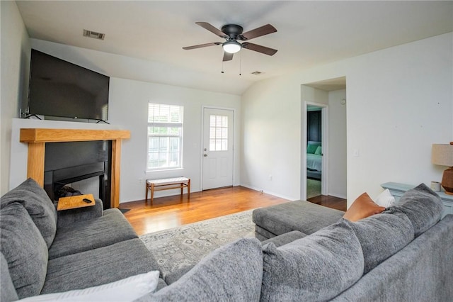 1041 Evergreen St, Centerton, AR 72719 - living area with wood finished floors, a ceiling fan, and a glass covered fireplace