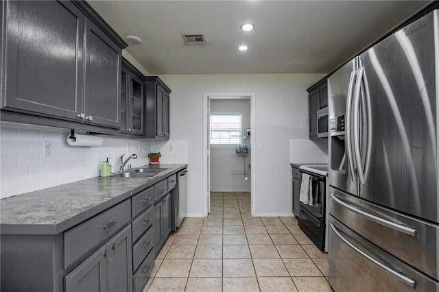 1041 Evergreen St, Centerton, AR 72719 - kitchen with appliances with stainless steel finishes, decorative backsplash, light tile patterned flooring, recessed lighting, and glass insert cabinets