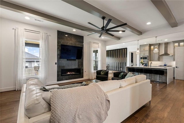 8002 W Claverton St, Rogers, AR 72758 - living room with beamed ceiling, a ceiling fan, dark wood-type flooring, a fireplace, and recessed lighting