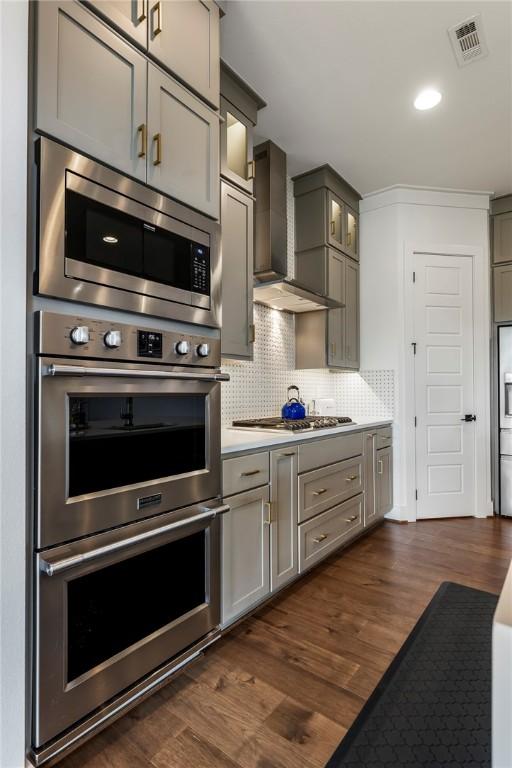 8002 W Claverton St, Rogers, AR 72758 - kitchen featuring stainless steel appliances, gray cabinets, wall chimney exhaust hood, dark wood-style floors, and recessed lighting
