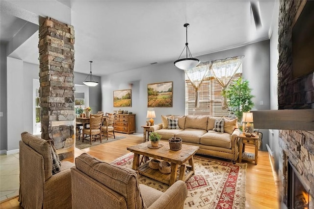 6629 Tall Oaks Loop, Springdale, AR 72762 - living room featuring ornate columns, a fireplace, and light wood-style floors