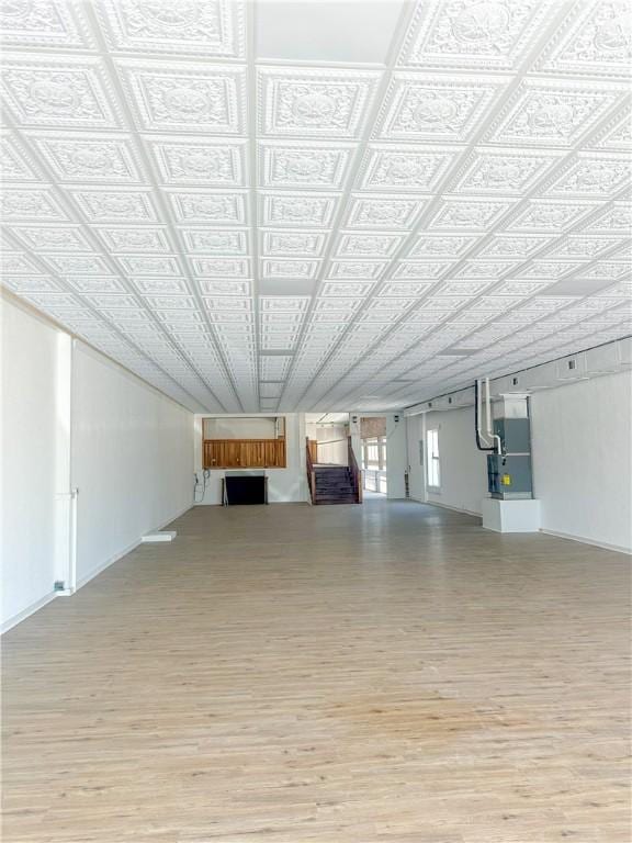 108 Public Sq, Berryville, AR 72616 - unfurnished living room featuring light wood-style flooring, an ornate ceiling, heating unit, and a fireplace