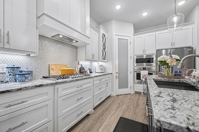 9116 Kirkwood Rdg, Fort Smith, AR 72916 - kitchen with appliances with stainless steel finishes, custom exhaust hood, white cabinetry, tasteful backsplash, and glass insert cabinets