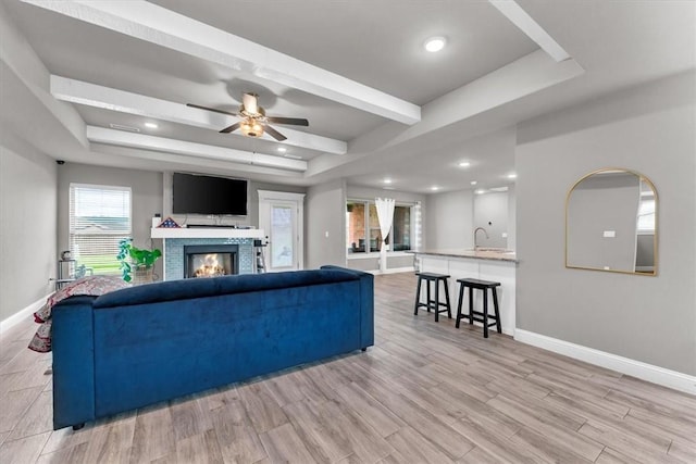 328 N Otoe St, Farmington, AR 72730 - living area with a glass covered fireplace, ceiling fan, light wood finished floors, a tray ceiling, and recessed lighting