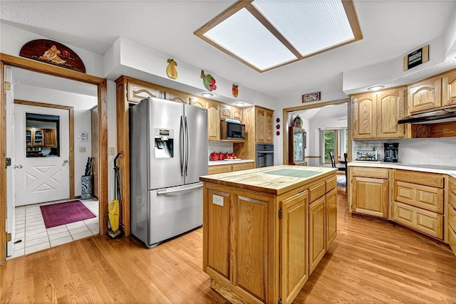 8553 Stoner Ln, Rogers, AR 72756 - kitchen featuring black appliances, wood counters, light wood-style floors, a kitchen island, and tasteful backsplash