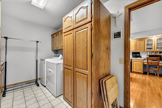 8553 Stoner Ln, Rogers, AR 72756 - laundry room with washer and dryer, cabinet space, an office area, a textured ceiling, and light tile patterned floors