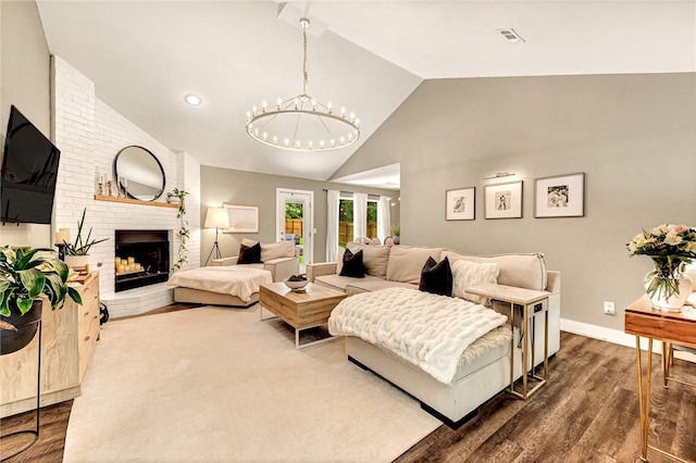 1314 N Fieldstone Ave, Fayetteville, AR 72704 - living room with high vaulted ceiling, dark wood-style flooring, a fireplace, and a chandelier