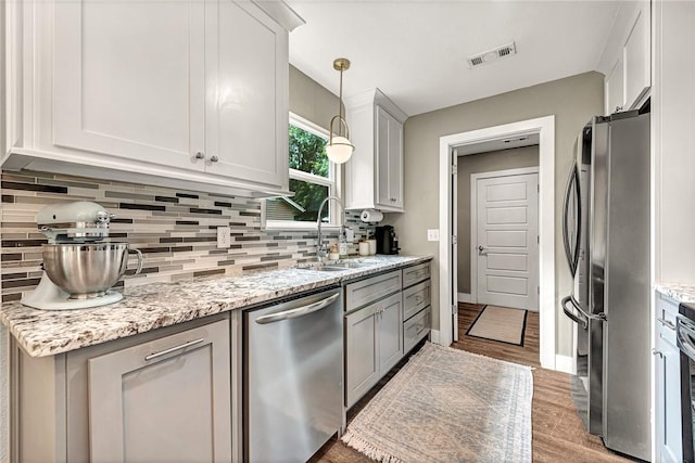 1314 N Fieldstone Ave, Fayetteville, AR 72704 - kitchen with stainless steel appliances, backsplash, wood finished floors, and light stone countertops