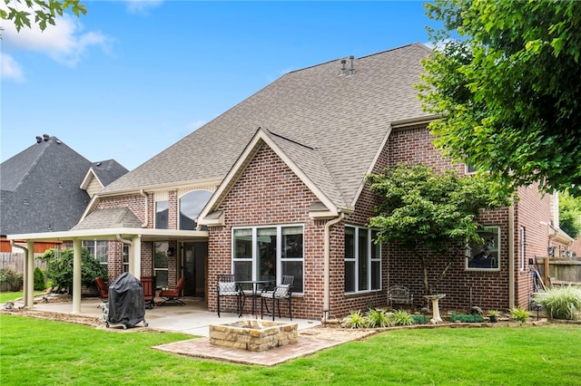 501 SE Fullerton St, Bentonville, AR 72712 - rear view of property featuring brick siding, a patio area, a shingled roof, and an outdoor fire pit