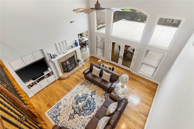 501 SE Fullerton St, Bentonville, AR 72712 - living room with a towering ceiling, wood finished floors, ceiling fan, and a lit fireplace