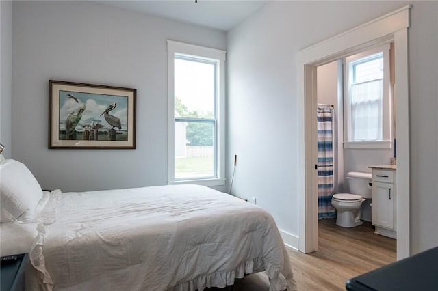 315 E 11th St, Fayetteville, AR 72701 - bedroom with light wood-type flooring, multiple windows, and connected bathroom