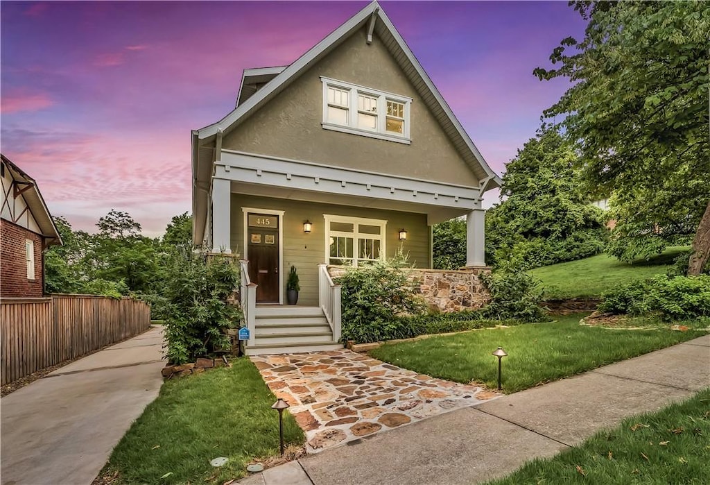 445 N Mock Ave, Fayetteville, AR 72701 - view of front of property featuring a porch, a front yard, and stucco siding