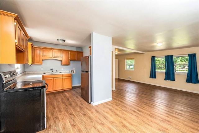 285 S 2nd St, Oaks, OK 74359 - kitchen with black range with electric cooktop, freestanding refrigerator, light wood-style flooring, open floor plan, and light countertops