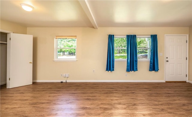 285 S 2nd St, Oaks, OK 74359 - unfurnished bedroom featuring multiple windows, wood finished floors, and beam ceiling