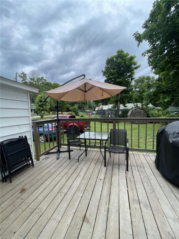 602 E Church Ave, Berryville, AR 72616 - wooden deck with a storage shed, a lawn, and a grill