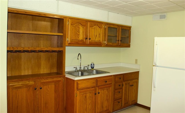 32 Table Rock Dr, Holiday Island, AR 72631 - kitchen with freestanding refrigerator, open shelves, brown cabinetry, and glass insert cabinets