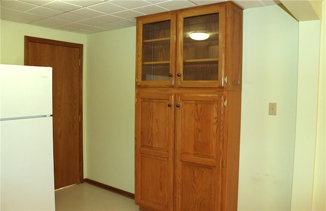 32 Table Rock Dr, Holiday Island, AR 72631 - kitchen featuring freestanding refrigerator, glass insert cabinets, and brown cabinetry