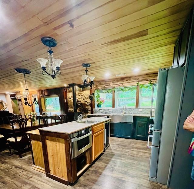 14163 Low Gap Wc 100 Rd, West Fork, AR 72774 - kitchen with a chandelier, appliances with stainless steel finishes, plenty of natural light, a center island with sink, and wood ceiling