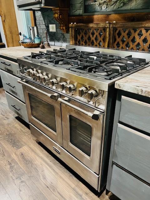 14163 Low Gap Wc 100 Rd, West Fork, AR 72774 - kitchen view of range with two ovens, light wood-style flooring, light countertops, and glass insert cabinets