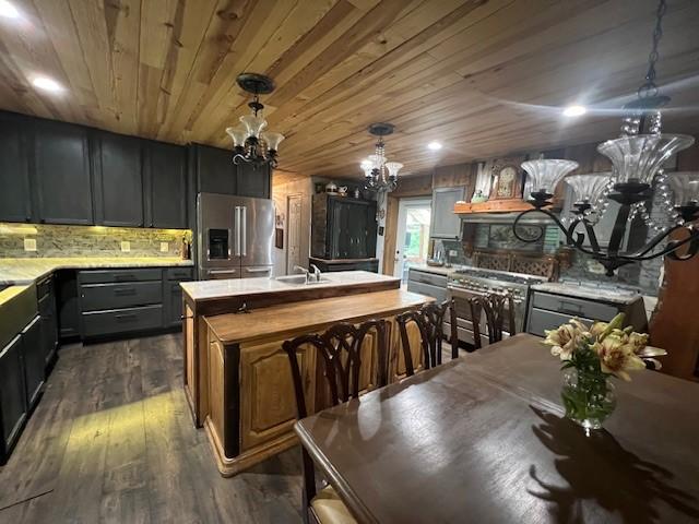 14163 Low Gap Wc 100 Rd, West Fork, AR 72774 - kitchen with appliances with stainless steel finishes, a chandelier, light countertops, a center island with sink, and dark wood-type flooring