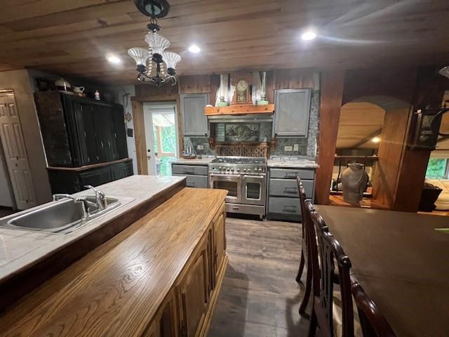 14163 Low Gap Wc 100 Rd, West Fork, AR 72774 - kitchen with range with two ovens, arched walkways, wood counters, gray cabinetry, and a chandelier