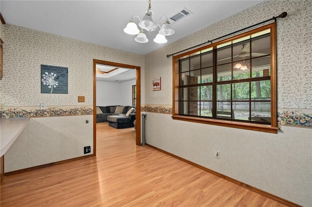 319 Belle Ave, Alma, AR 72921 - unfurnished room with wallpapered walls, wood finished floors, a chandelier, and wainscoting
