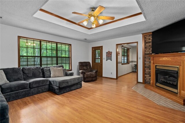 319 Belle Ave, Alma, AR 72921 - living room with a raised ceiling, light wood-style floors, ceiling fan, a textured ceiling, and a fireplace